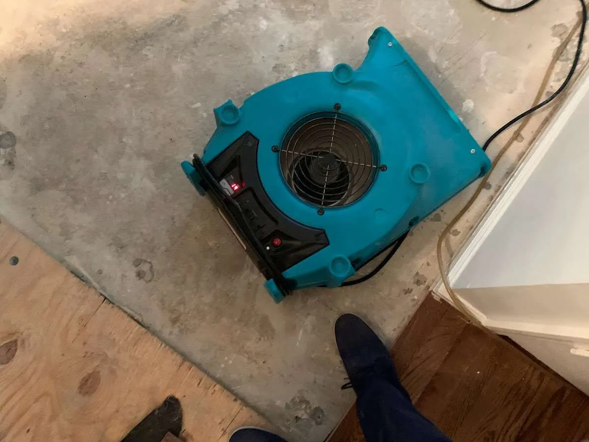 Air mover drying subfloor during Leak Detection & Repair in Struthers